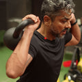 Man lifting a kettlebell in a gym setting wearing Agile tee