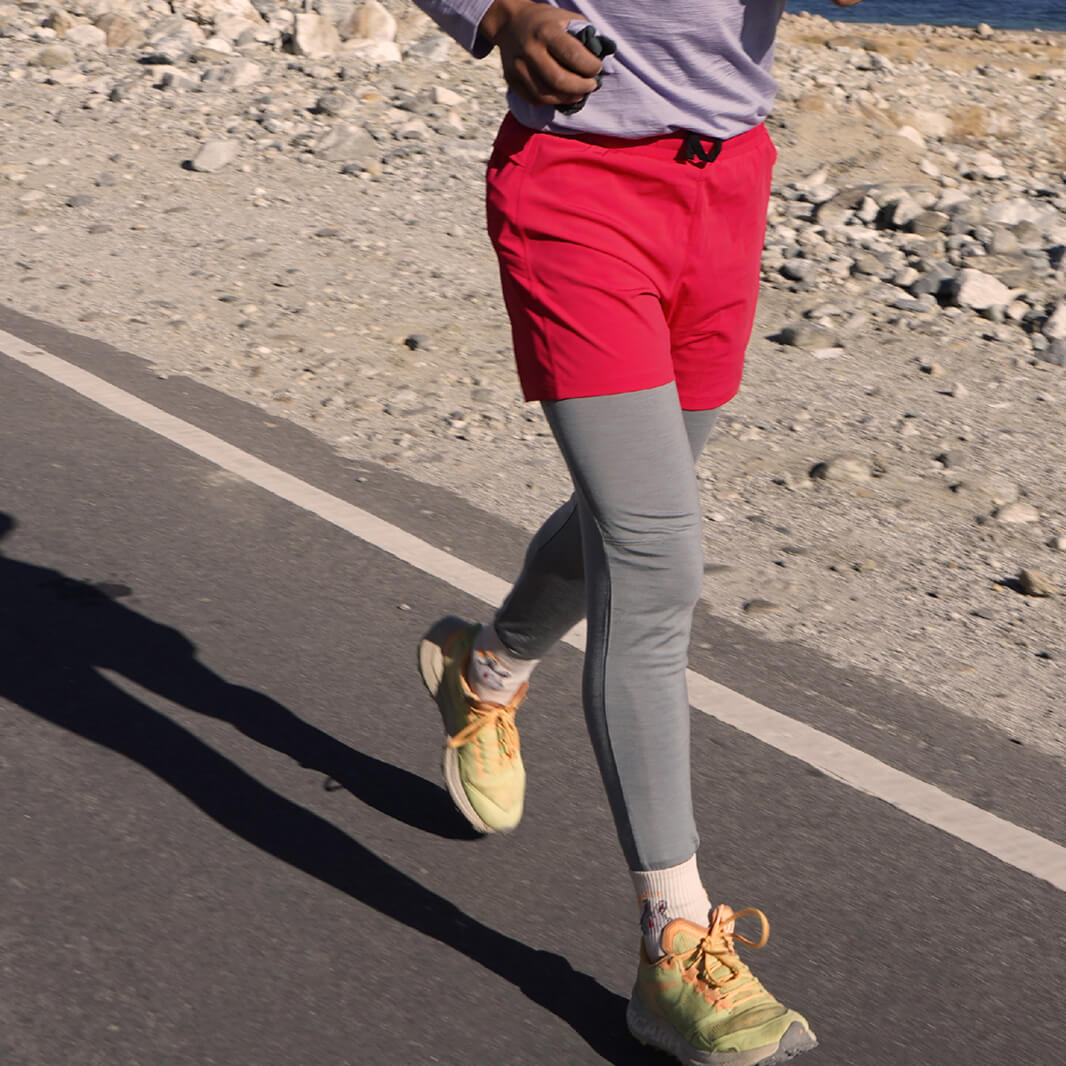 Person running on a road in merino baselayer leggings