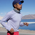 Person running with a scenic background of mountains and water wearing Athlos baselayer