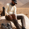 Man sitting on a rock in a desert landscape with hiking shoes beside him wearing Athlos Convertible Pants