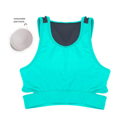 Women wearing a green Athlos Mid Intensity bra with a neutral background