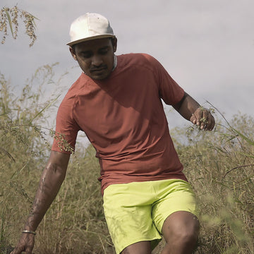 Man in a zero tee walking through tall grass.