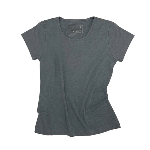 Woman in a gray Athlos Distane t-shirt sitting outdoors with trees in the background